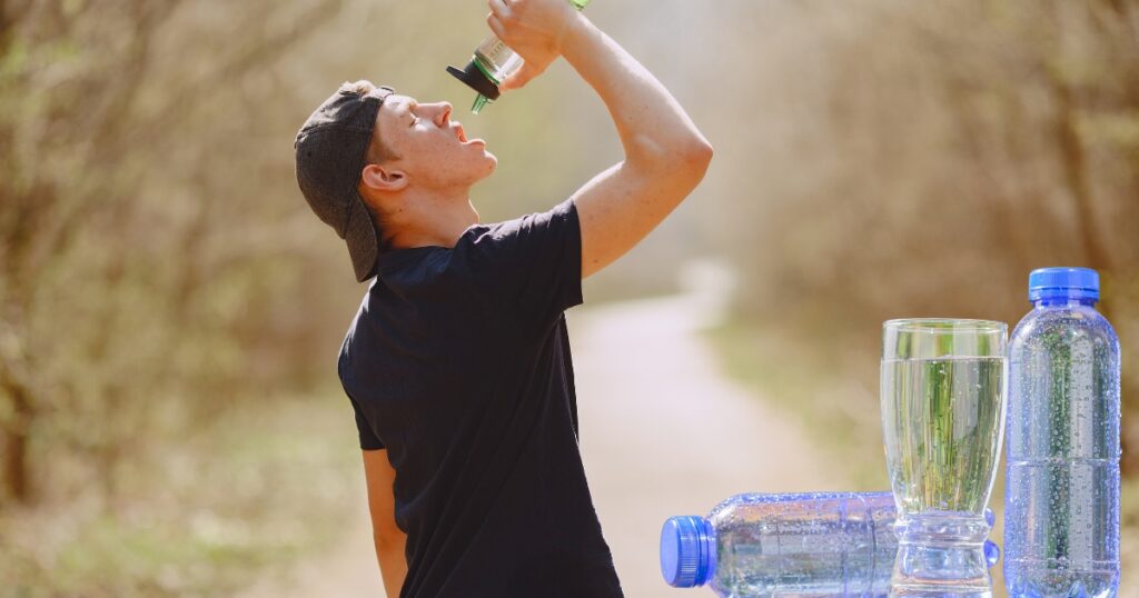 "Boy drinking water from a bottle outdoors."